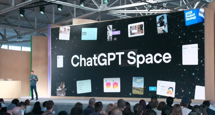 Pembentangan pentas secara langsung memaparkan skrin gergasi berlatarbelakangkan angkasa dengan tulisan "ChatGPT Space" dan beberapa kad antara muka digital, disaksikan oleh penonton di dewan acara.